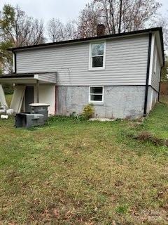 rear view of property with a yard