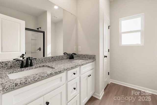 bathroom with wood-type flooring, vanity, and walk in shower