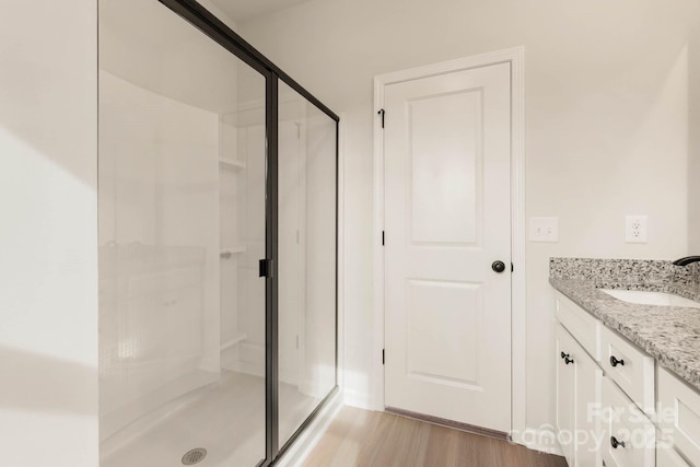 bathroom featuring vanity, wood-type flooring, and walk in shower