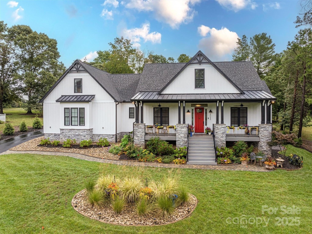 modern farmhouse style home featuring a porch and a front yard