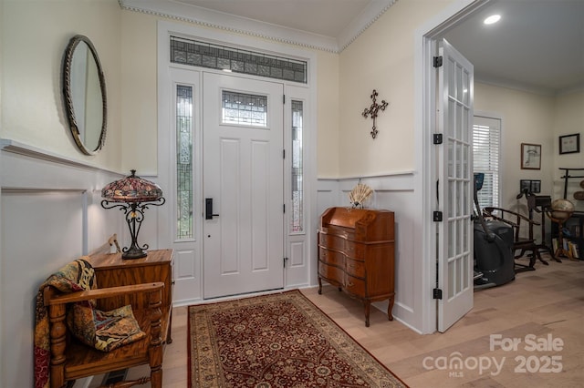 entryway featuring light wood-type flooring and ornamental molding