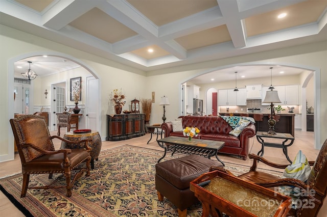 living room featuring a notable chandelier, beam ceiling, french doors, and coffered ceiling