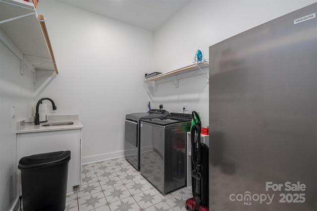 laundry area with independent washer and dryer and sink