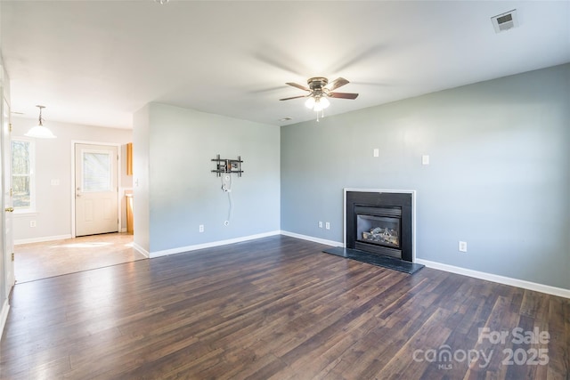 unfurnished living room featuring ceiling fan and dark hardwood / wood-style flooring