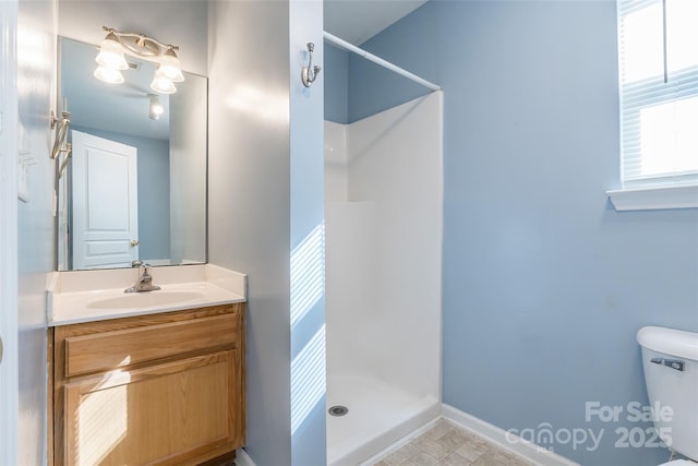 bathroom with toilet, vanity, and walk in shower