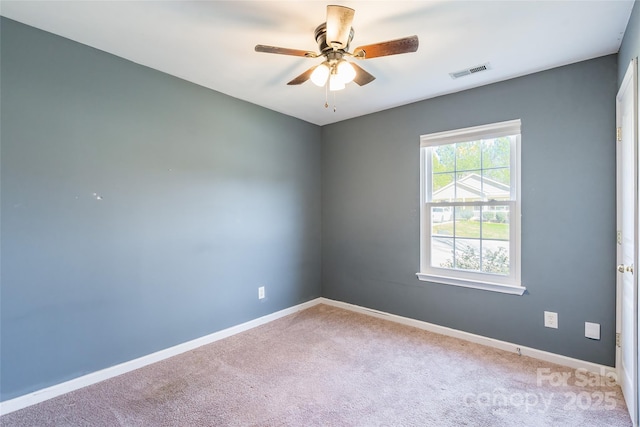 carpeted spare room with ceiling fan