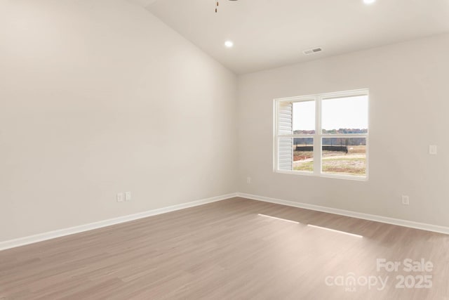 empty room with lofted ceiling, ceiling fan, and light wood-type flooring