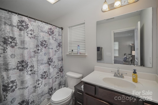 bathroom with toilet, a shower with curtain, and vanity