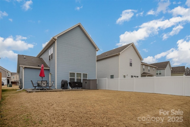 back of house featuring a patio area and a lawn