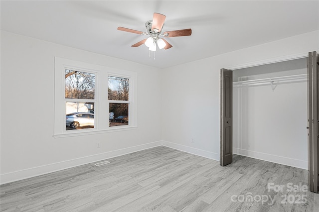 unfurnished bedroom with ceiling fan, light hardwood / wood-style floors, and a closet