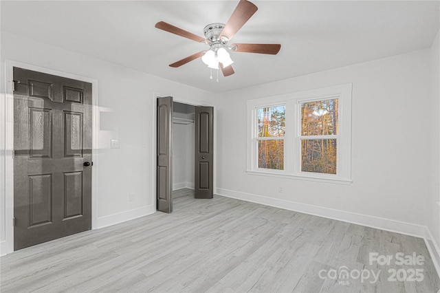 unfurnished bedroom with a closet, light hardwood / wood-style floors, and ceiling fan