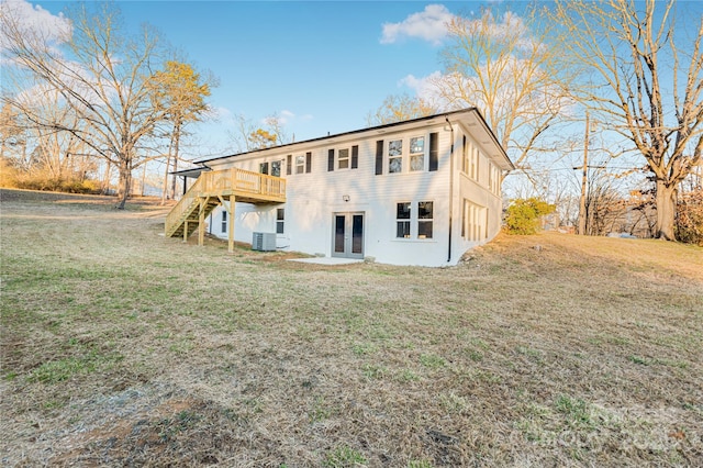 rear view of property with a yard, central AC, and a wooden deck