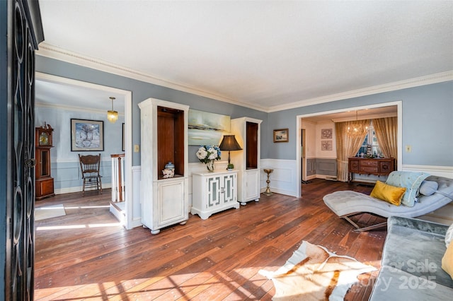 living room featuring dark hardwood / wood-style flooring, an inviting chandelier, and ornamental molding