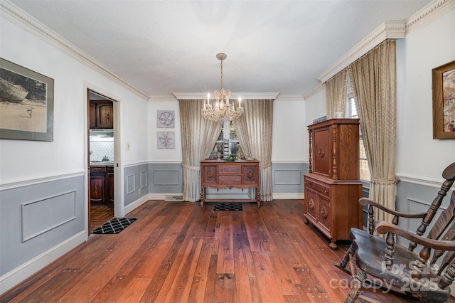 living area featuring an inviting chandelier, dark hardwood / wood-style floors, and ornamental molding