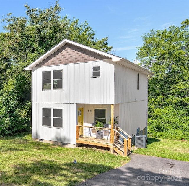 view of front of property featuring a porch, a front yard, and central AC unit