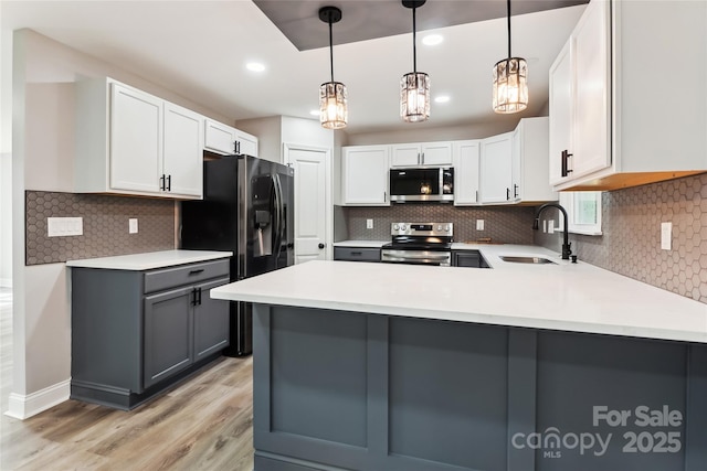 kitchen with sink, decorative light fixtures, white cabinetry, gray cabinets, and appliances with stainless steel finishes