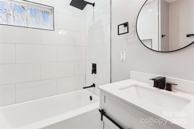 bathroom featuring tiled shower / bath and vanity