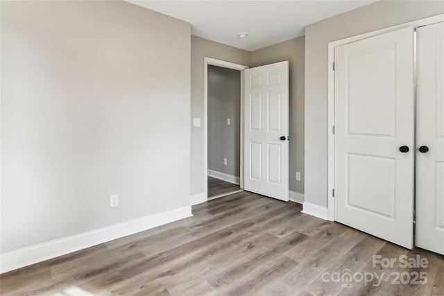 unfurnished bedroom featuring a closet and light hardwood / wood-style floors