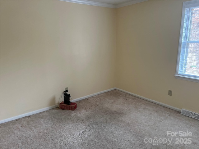 spare room featuring a wealth of natural light, visible vents, and carpet