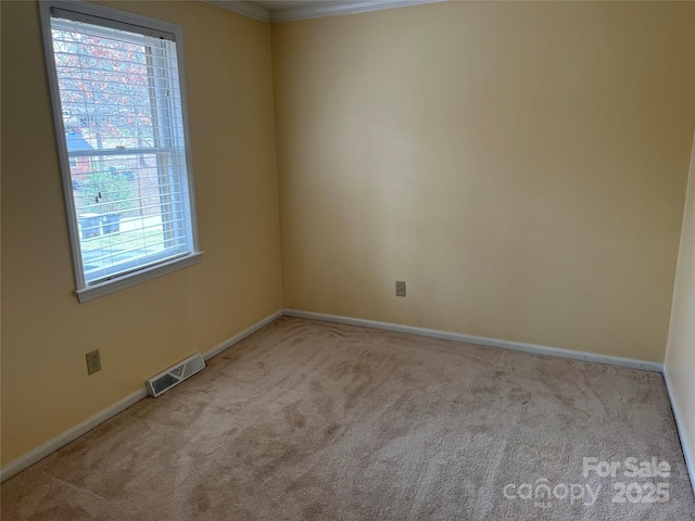 carpeted spare room with baseboards and visible vents