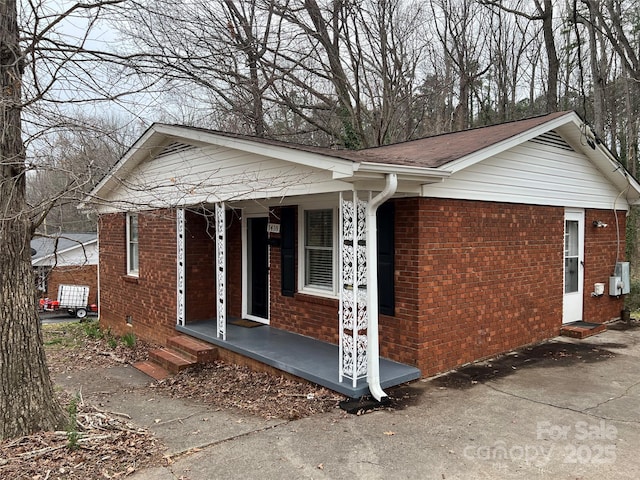 view of front of home featuring brick siding, crawl space, and a porch