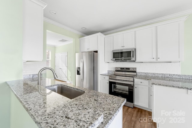 kitchen featuring light stone countertops, white cabinetry, and appliances with stainless steel finishes