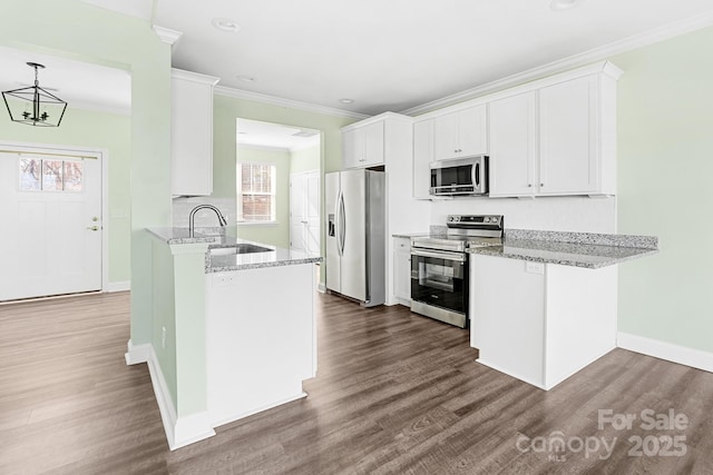 kitchen with kitchen peninsula, sink, white cabinetry, light stone countertops, and appliances with stainless steel finishes