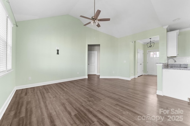 unfurnished living room with dark wood-type flooring, ceiling fan, plenty of natural light, and vaulted ceiling