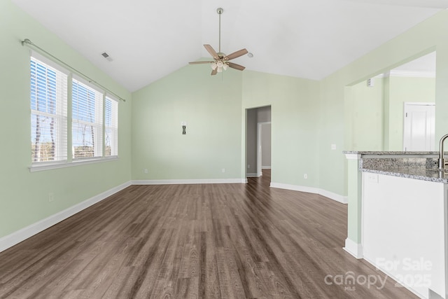 unfurnished living room with ceiling fan, vaulted ceiling, and dark wood-type flooring