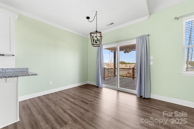 unfurnished dining area featuring dark wood-type flooring, an inviting chandelier, and ornamental molding