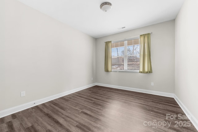 spare room with dark wood-type flooring