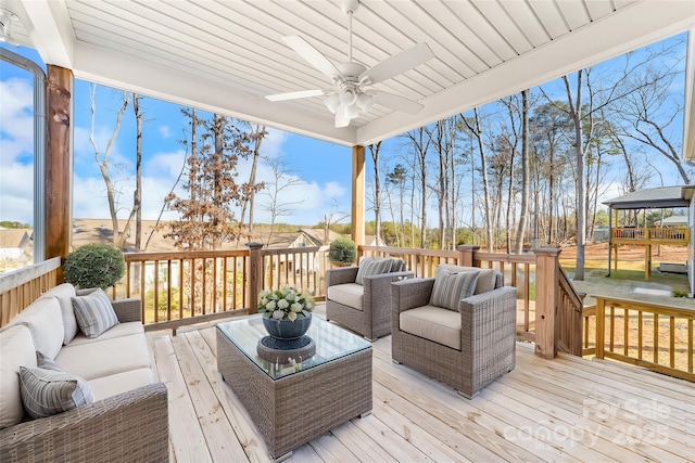 wooden deck with ceiling fan and outdoor lounge area