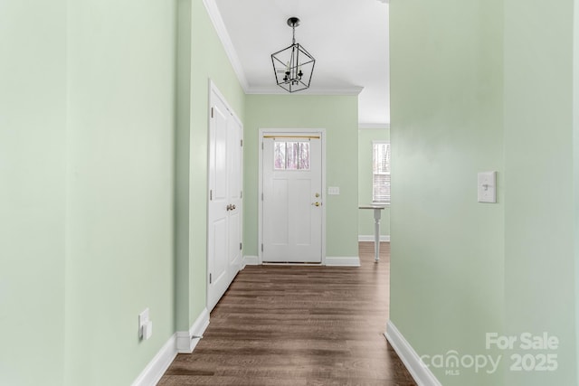 interior space with dark hardwood / wood-style flooring, ornamental molding, and a notable chandelier