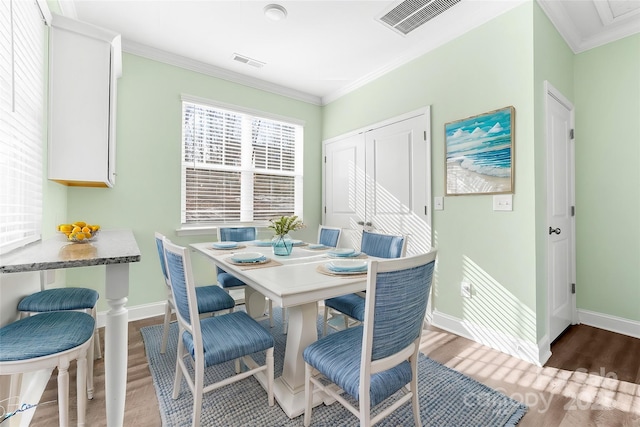 dining area featuring breakfast area, ornamental molding, and wood-type flooring