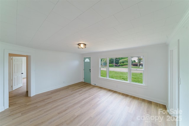 empty room with light wood-type flooring and ornamental molding