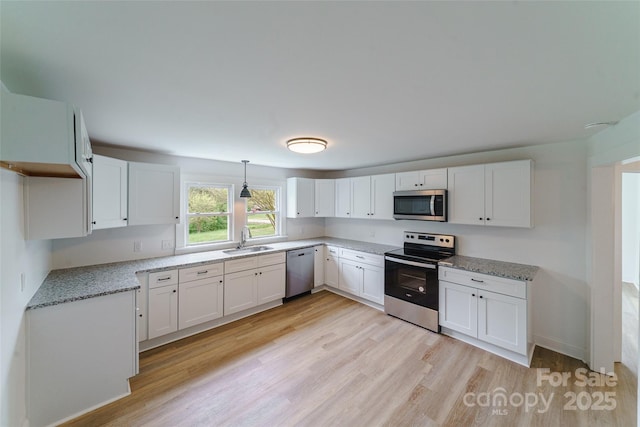 kitchen featuring stainless steel appliances, sink, pendant lighting, light hardwood / wood-style flooring, and white cabinets