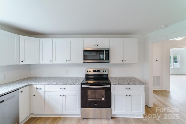 kitchen featuring light stone countertops, white cabinets, and appliances with stainless steel finishes