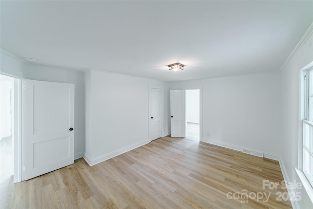 unfurnished room with light hardwood / wood-style flooring and crown molding