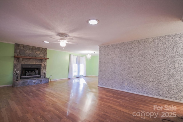 unfurnished living room featuring a stone fireplace, ceiling fan, and hardwood / wood-style floors