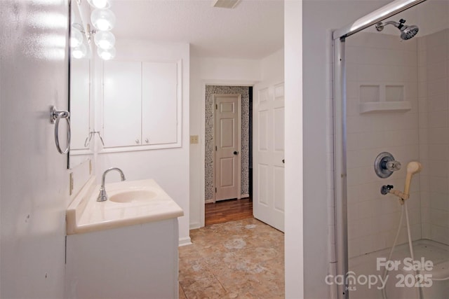 bathroom with a shower with door and vanity