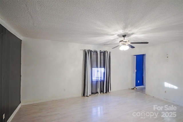 empty room featuring a textured ceiling, light hardwood / wood-style floors, and ceiling fan