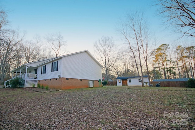 view of side of home featuring a porch and an outdoor structure