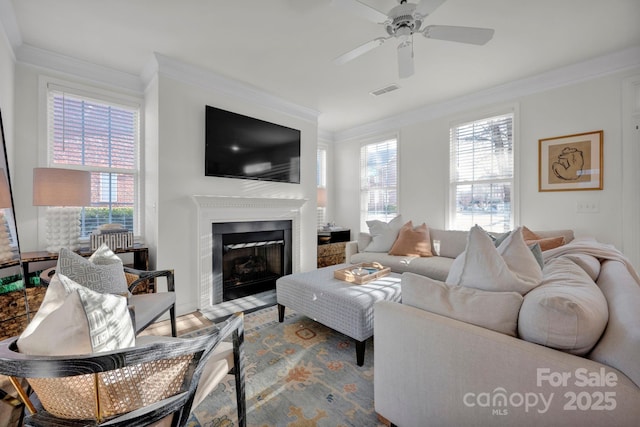 living room with ceiling fan, wood-type flooring, crown molding, and a wealth of natural light