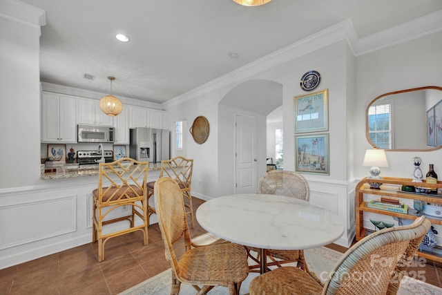 dining room featuring crown molding and dark tile patterned floors