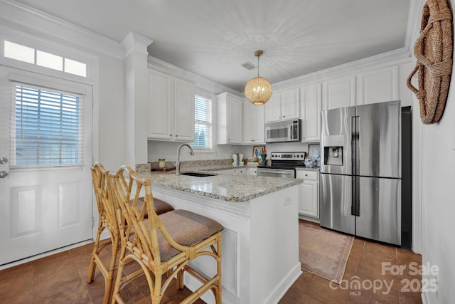 kitchen featuring white cabinets, dark tile patterned flooring, hanging light fixtures, kitchen peninsula, and stainless steel appliances