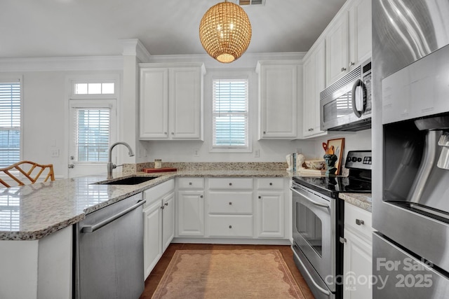 kitchen with sink, white cabinets, decorative light fixtures, and appliances with stainless steel finishes