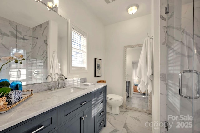 bathroom featuring vanity, toilet, and a shower with door