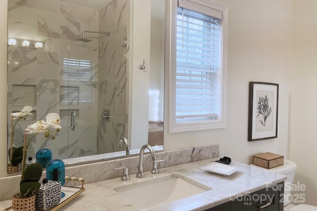 bathroom featuring vanity, toilet, an enclosed shower, and plenty of natural light