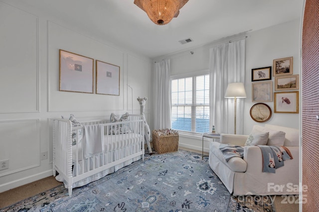 bedroom featuring carpet and a nursery area