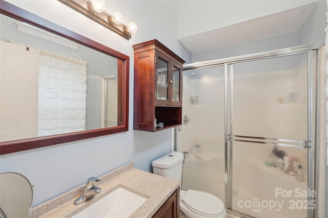 bathroom featuring vanity, toilet, and an enclosed shower